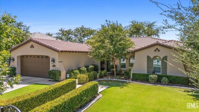 mediterranean / spanish-style home featuring a garage and a front yard