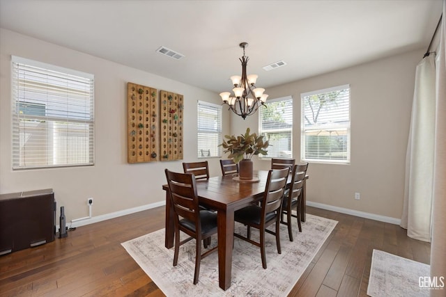 dining space featuring an inviting chandelier and dark hardwood / wood-style floors