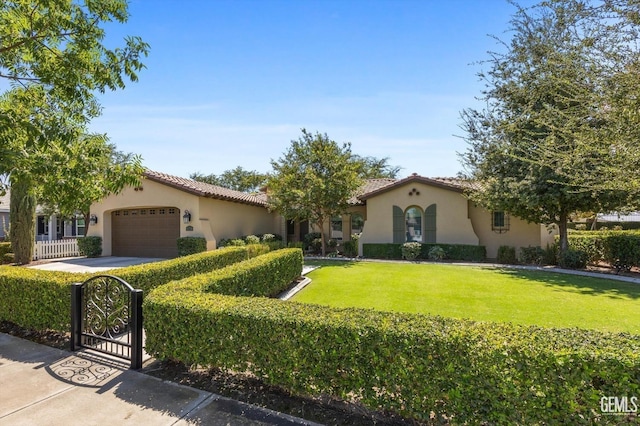 mediterranean / spanish-style house featuring a garage and a front lawn