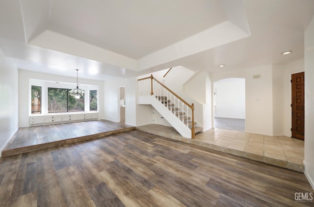 8226 Birmingham St, Bakersfield, CA 93311 - unfurnished living room featuring a tray ceiling, wood finished floors, stairway, baseboards, and recessed lighting
