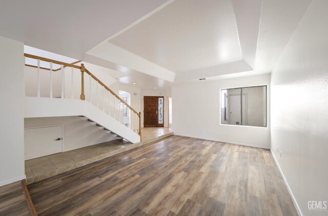 8226 Birmingham St, Bakersfield, CA 93311 - unfurnished living room featuring a tray ceiling, stairs, wood finished floors, and baseboards