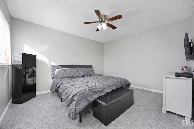 carpeted bedroom featuring a ceiling fan, a textured ceiling, and baseboards