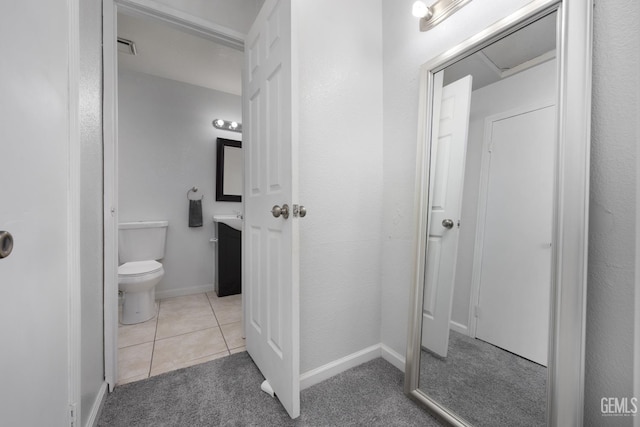 bathroom with visible vents, toilet, vanity, baseboards, and tile patterned floors