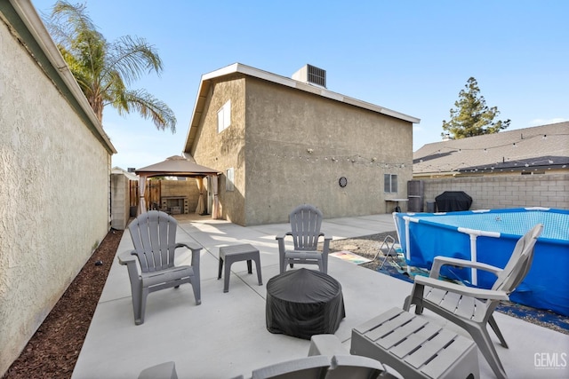 view of patio / terrace with a fenced in pool, area for grilling, a fenced backyard, a gazebo, and central AC