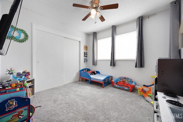 rec room with a ceiling fan, carpet, and a textured ceiling