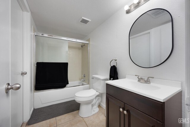 full bathroom featuring visible vents, toilet, tile patterned flooring, combined bath / shower with glass door, and vanity