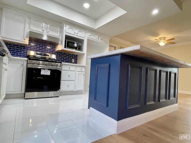 kitchen featuring white cabinetry, gas stove, decorative backsplash, and light wood-type flooring