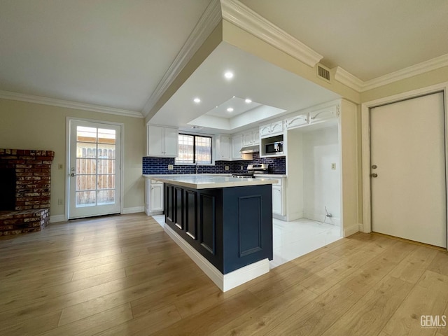 kitchen with white cabinetry, stainless steel appliances, light hardwood / wood-style floors, and a kitchen island