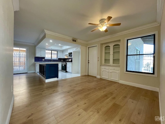 kitchen featuring crown molding, light hardwood / wood-style flooring, appliances with stainless steel finishes, white cabinets, and a kitchen bar