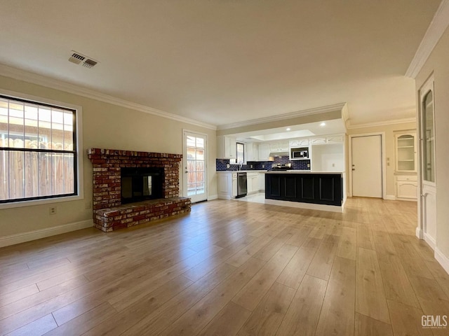 unfurnished living room with a fireplace, ornamental molding, and light wood-type flooring