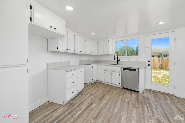 kitchen featuring stainless steel dishwasher, a sink, light wood finished floors, light countertops, and recessed lighting