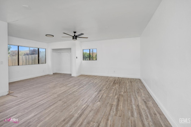 unfurnished room with ceiling fan, wood finished floors, and baseboards