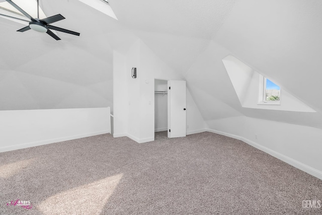 additional living space featuring vaulted ceiling, carpet, ceiling fan, and baseboards