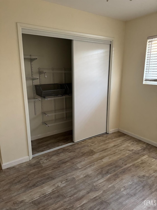 unfurnished bedroom featuring hardwood / wood-style flooring and a closet