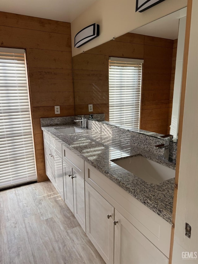 bathroom featuring hardwood / wood-style flooring, vanity, and wooden walls