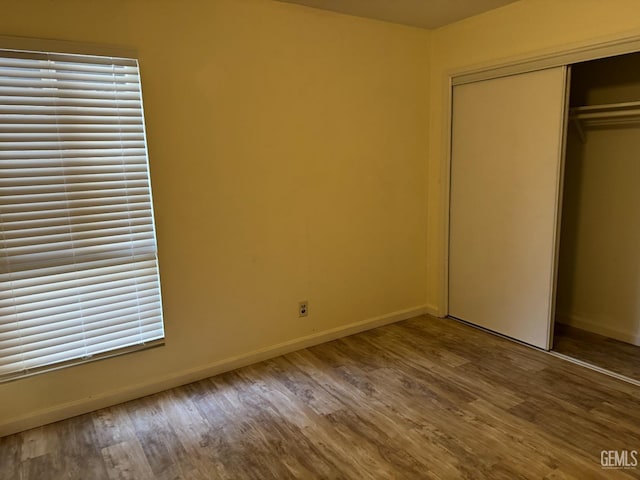 unfurnished bedroom with wood-type flooring and a closet