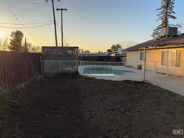 pool at dusk featuring a patio area and central air condition unit