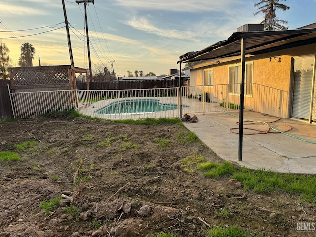 pool at dusk featuring cooling unit and a patio area