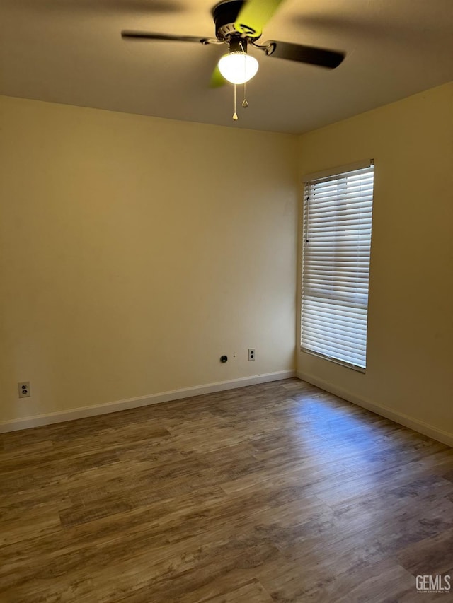 spare room featuring dark hardwood / wood-style flooring and ceiling fan