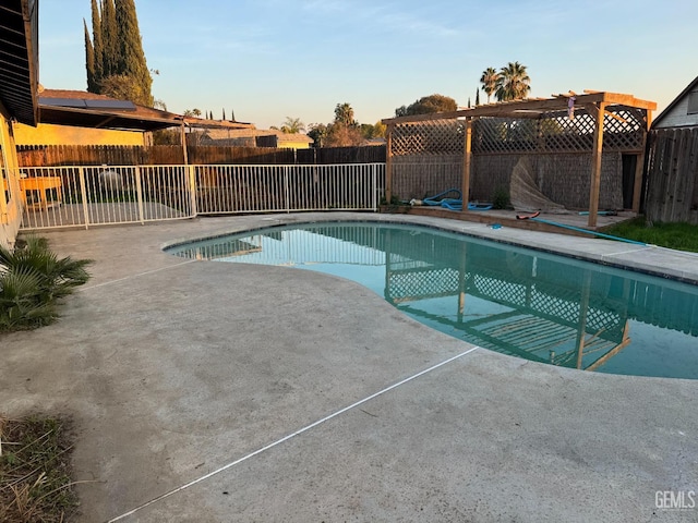 pool at dusk featuring a patio and a pergola