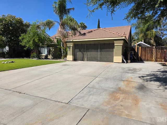 10302 Willow Bend Ct, Bakersfield, CA 93312 - view of front of house with a tiled roof, an attached garage, stucco siding, and driveway