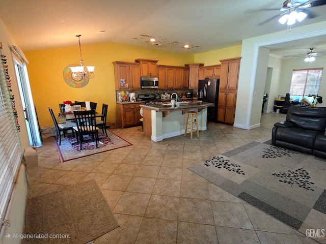 10302 Willow Bend Ct, Bakersfield, CA 93312 - kitchen featuring stainless steel appliances, open floor plan, a breakfast bar area, a ceiling fan, and brown cabinetry