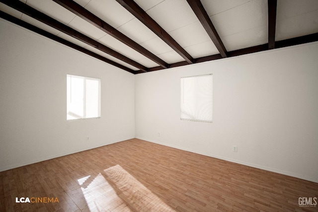 unfurnished room with lofted ceiling with beams and wood-type flooring