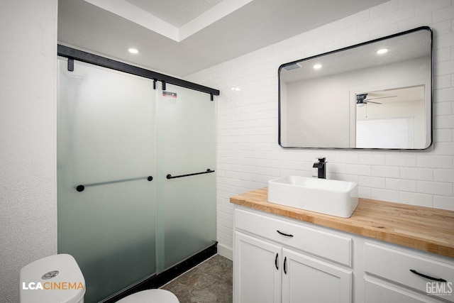 bathroom with an enclosed shower, ceiling fan, toilet, and vanity