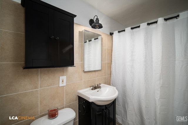 bathroom with decorative backsplash, toilet, tile walls, and vanity