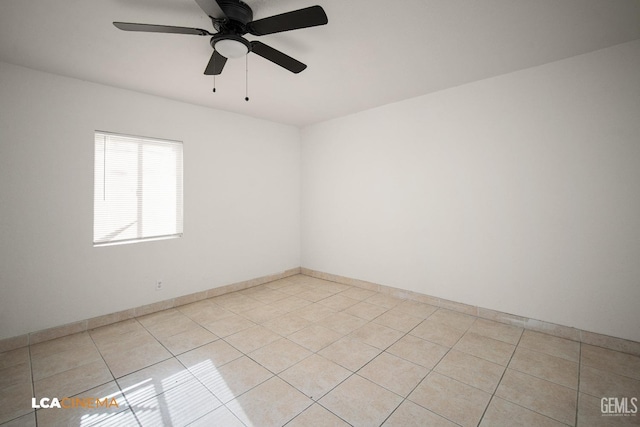 tiled empty room featuring ceiling fan