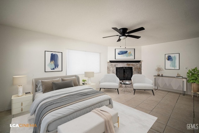 tiled bedroom with a textured ceiling, ceiling fan, and a fireplace