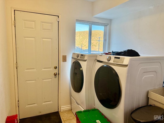 washroom featuring light tile patterned flooring and washer and clothes dryer