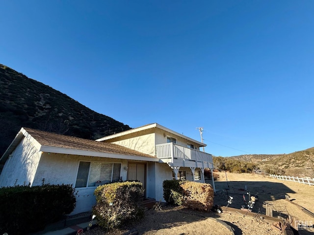 view of home's exterior with a balcony and a mountain view