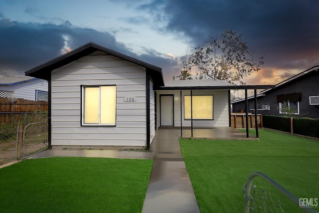 view of front of home with a front lawn, fence, and a patio