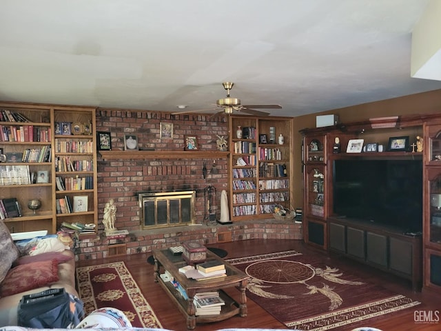 living room with a brick fireplace, dark hardwood / wood-style floors, and ceiling fan