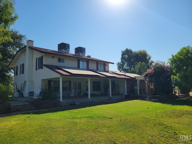 rear view of house featuring a patio, central AC unit, and a lawn