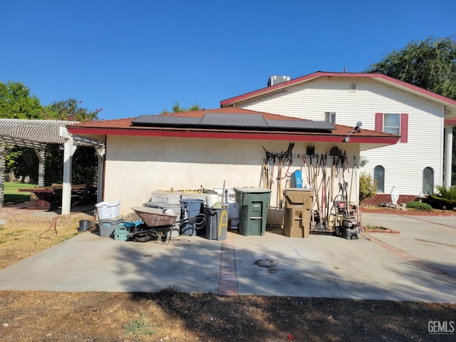 view of side of home featuring a pergola, central AC, and solar panels