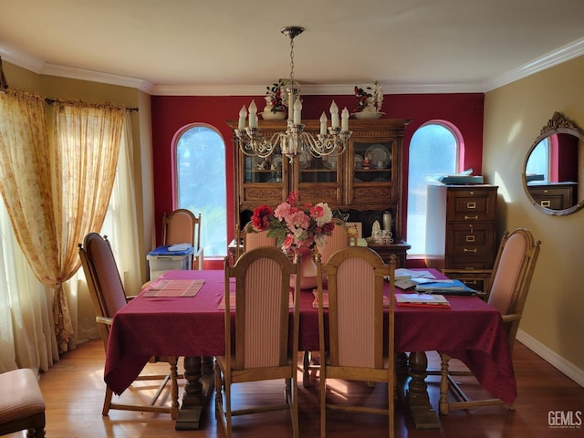 dining room with hardwood / wood-style floors, ornamental molding, and a chandelier