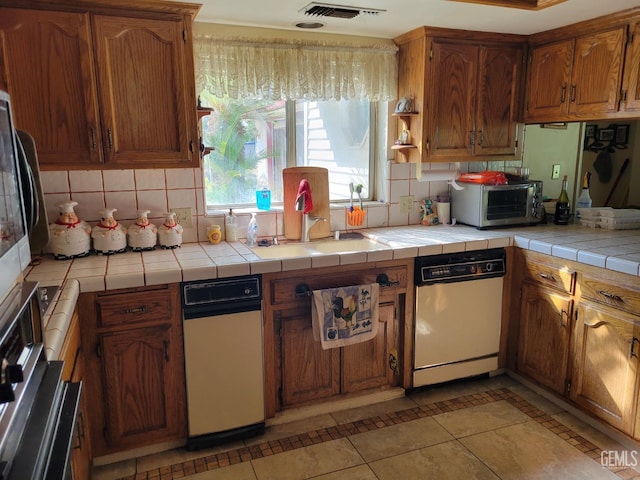 kitchen featuring light tile patterned flooring, tile counters, and backsplash