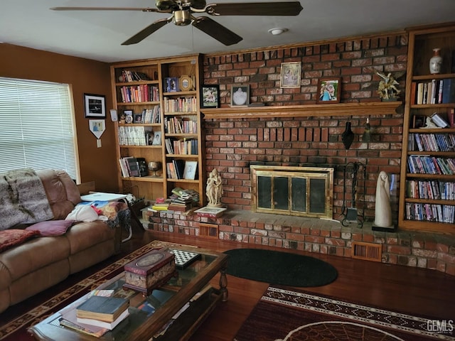 living room featuring a brick fireplace and ceiling fan