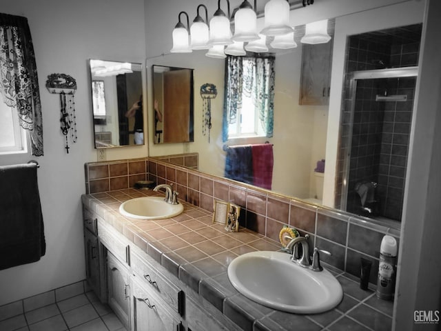 bathroom featuring tile patterned floors, a shower with shower door, vanity, and backsplash