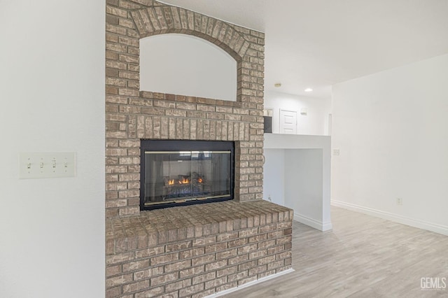 interior details with hardwood / wood-style flooring and a brick fireplace