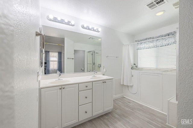 bathroom featuring a shower, wood-type flooring, a textured ceiling, and vanity