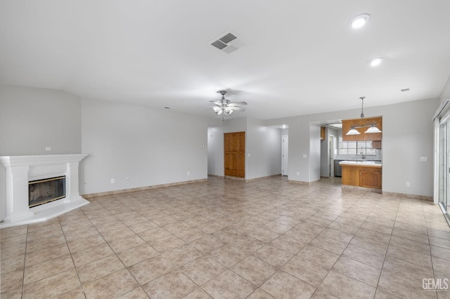 unfurnished living room with ceiling fan and light tile patterned flooring