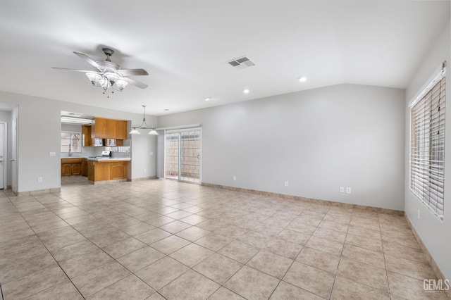 unfurnished living room with vaulted ceiling, ceiling fan, and light tile patterned flooring