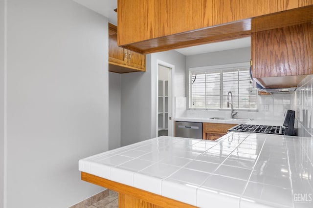 kitchen with dishwasher, tile counters, sink, decorative backsplash, and light tile patterned floors