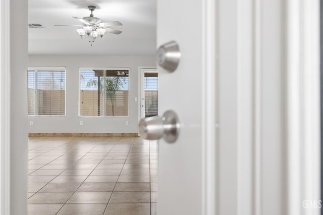 interior space with light tile patterned floors and ceiling fan