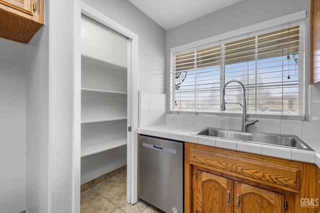 kitchen featuring dishwasher, sink, tasteful backsplash, tile counters, and light tile patterned flooring