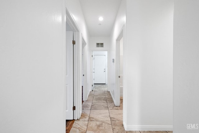 corridor featuring marble finish floor, visible vents, and baseboards