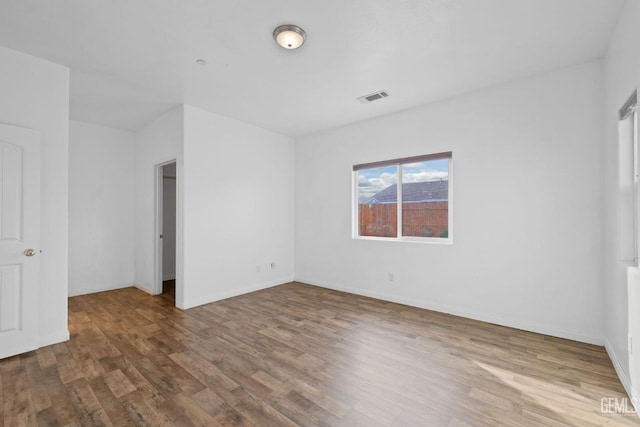 unfurnished bedroom featuring baseboards, visible vents, and wood finished floors